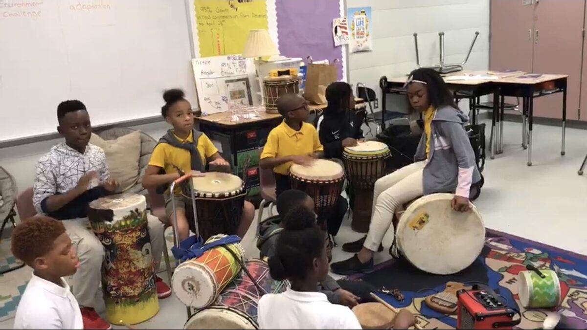 Students playing ancestral djembe drums as part of a sound and vibration lesson